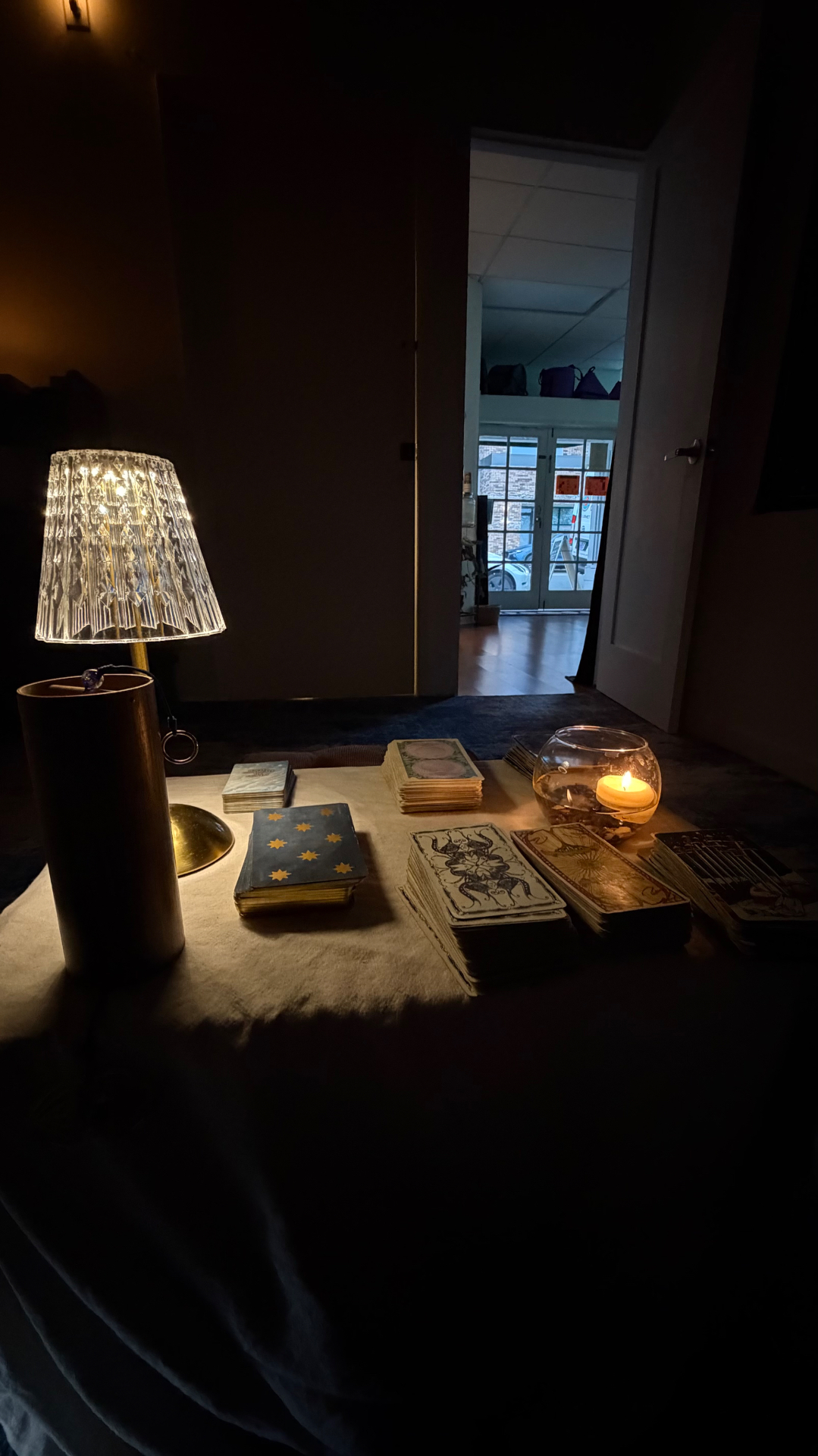 Tarot decks lit by candlelight on a reading table
